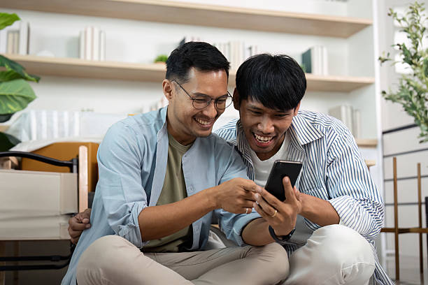 istock Gay couple sharing laughter while exploring their smartphone 2221101504