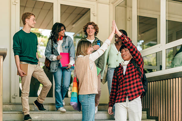istock Happy students giving high five at university campus 2221101902