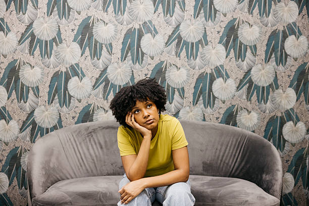 istock Young woman feeling bored at home sitting on sofa 2221103376