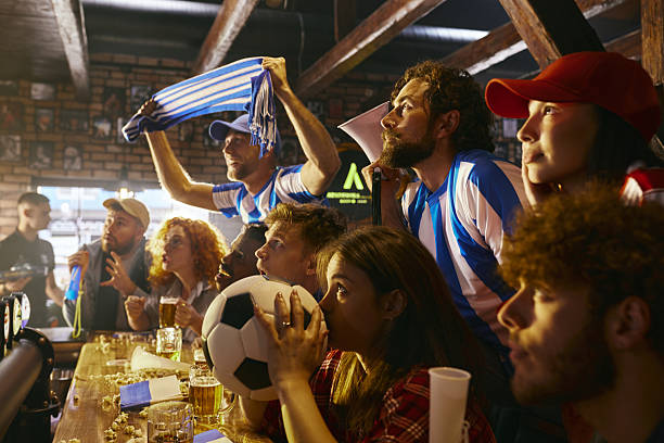 istock Watching a suspenseful soccer match on TV in a pub! 2221103703