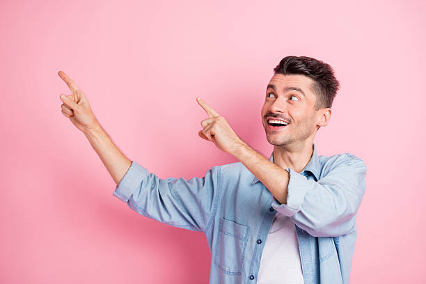 istock Portrait of nice cheerful guy demonstrating ad copy empty blank space offer rate isolated over pink pastel color background 2221106224