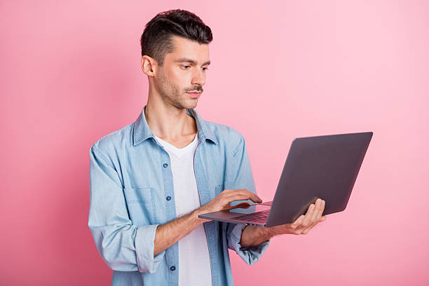 istock Photo portrait young entrepreneur working computer serious confident reading information isolated pastel pink color background 2221106234