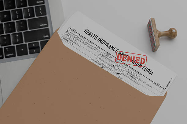 istock insurance claim form with denied on the table. 2221106366