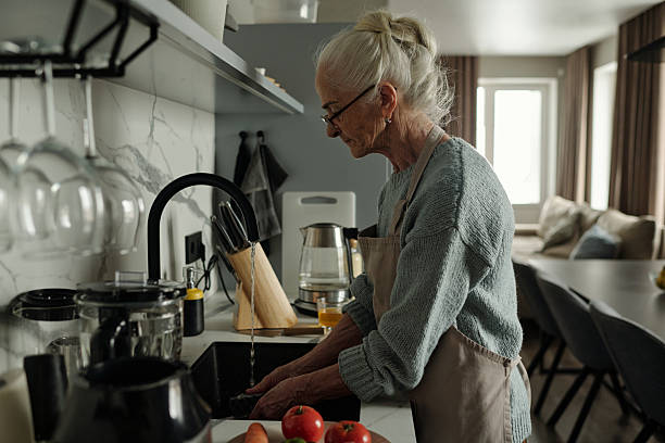 istock Senior Woman Washing Vegetables in Home Kitchen 2221109249