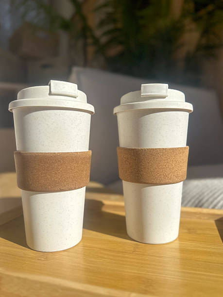 istock Two plastic takeaway coffee cups with protective sleeves, placed on a tray on table in a warm, neutral-toned home interior. 2221121380