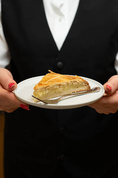 Waiter with a slice of cake on a plate in his hand