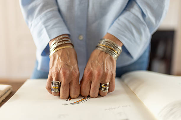 Portrait beautiful An Asian woman with jewelry. Close-up of an Asian woman with luxury accessories such as diamond ring, necklace and silver bracelet with yellow background.