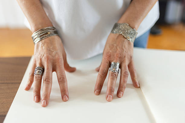 Woman is showing the jewelry she designed. She is a designer and artist of unique jewelry made of precious metal. She is doing all process phases from design, manufacture and quality control.