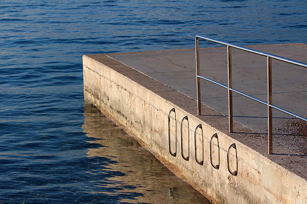 istock Concrete pier with stainless steel railings and water access ladders 2221128352