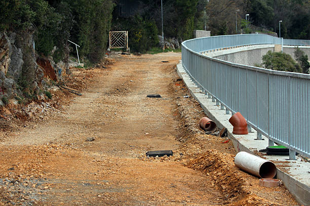 istock Gravel construction path with metal railing and drainage pipes 2221128575