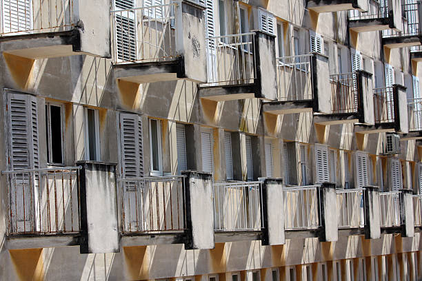 istock Repetitive balconies and shutters on weathered apartment building 2221129218