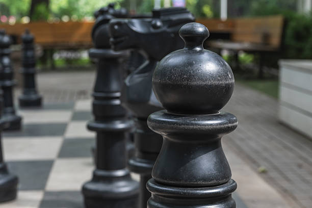 Public space for playing chess in a street park. Giant black chess. Selective focus.