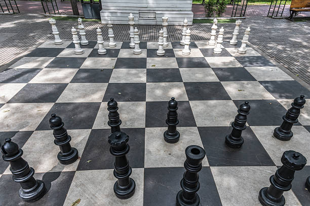 istock Chessboard with giant chess pieces in a street park 2221133054
