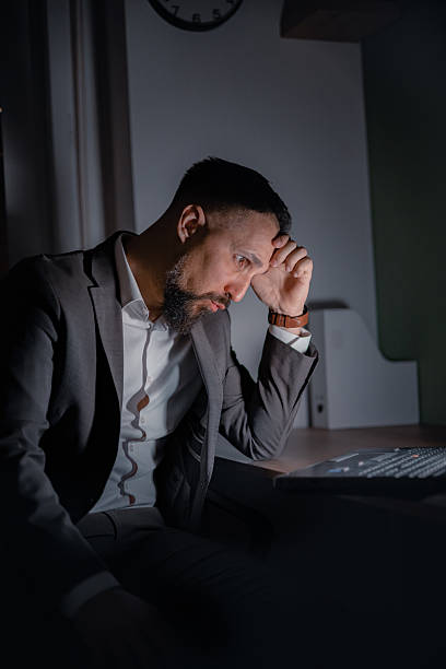 istock Unhappy man working overtime, head in hands, feeling drained and dissatisfied – late-night hustle, job frustration, burnout symptoms. 2221133634