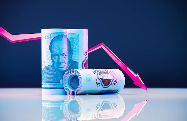 istock Rolled British Five Pound Notes And Pink Line Graph On Dark Blue Background - Market Volatility Concept 2221133737