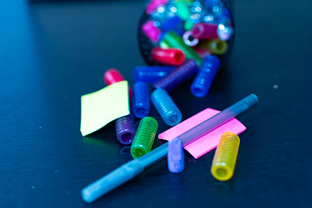 Blue ball point pen situated next to small sticky notes and rubber pen grips.