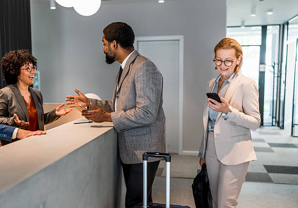 istock Businesspeople checking in at hotel reception desk 2221138331