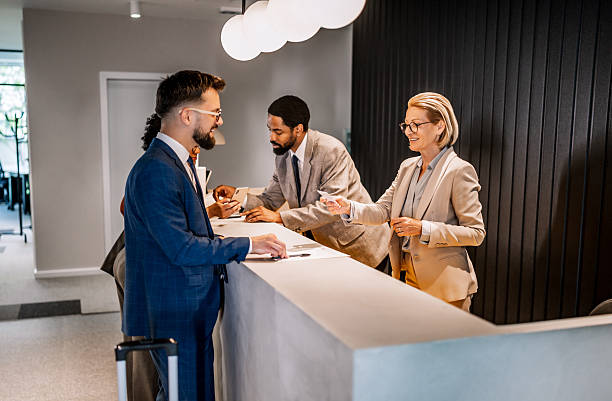 istock Businesspeople doing check in at hotel reception 2221138614