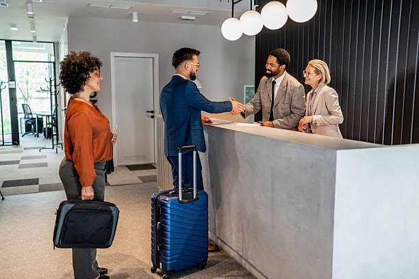 istock Businesspeople arriving at hotel reception shaking hands 2221138743