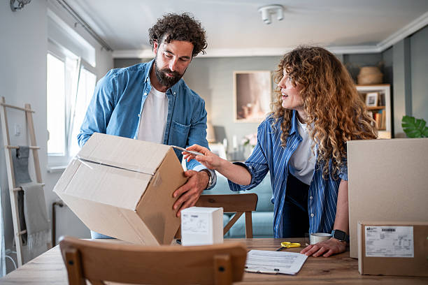 istock Couple packing cardboard boxes and moving into new home 2221144165
