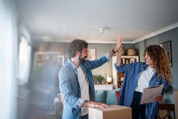 istock Happy couple giving high five while unpacking boxes in new home 2221144254