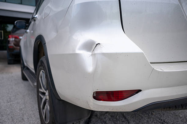 istock Car rear bumper with large dent and cracked paint 2221156919