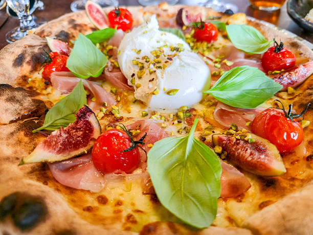 Pizza with cheese, burrata, fig, cherry tomatos, basil and ham Pizza with cheese, burrata, fig, cherry tomatos, basil and ham