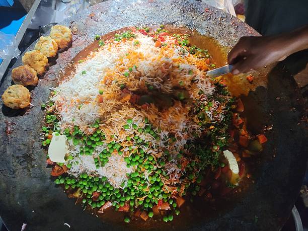 Man cooking street food Biryani on a busy street