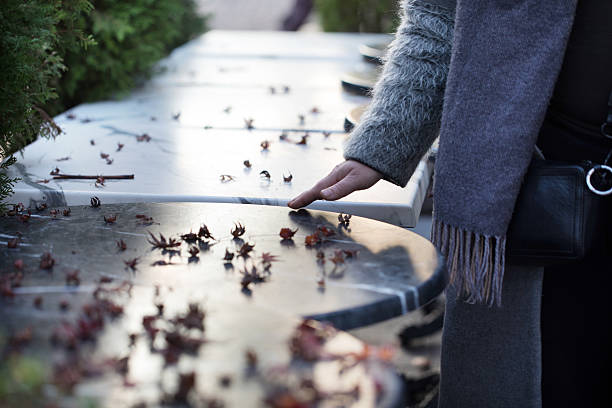 Touching a Cold Marble Surface Scattered With Leaves During a Serene Afternoon in a Garden, Evoking Memories and Contemplation