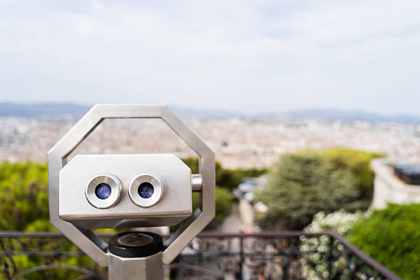 Scenic cityscape view through stationary binoculars on a clear day, capturing an expansive city view.
