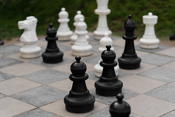 istock Big chess pieces pawn on the board. Green background behind. 2221178410