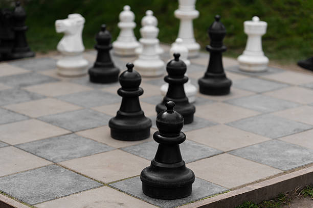 istock Big chess pieces pawn on the board. Green background behind. 2221178424