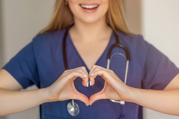 istock Smiling nurse with stethoscope expressing care and love through a heart gesture 2221179314