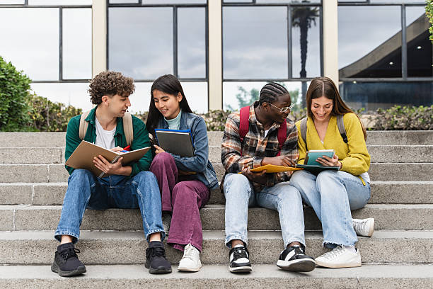 istock Group of Uni students preparing for University exams sitting on the staircase learning together 2221181570