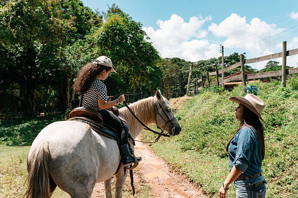 Young girl learning to steer horse