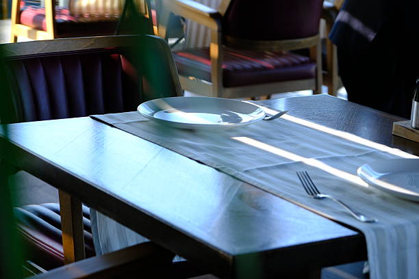 Table arrangement before dinner at a luxury restaurant. Waiters' service preparations. White tablecloths. Design of plates, forks and knives. Celebration dinner, lunch. Restaurant with Bosphorus view. Elegant dining table. Dinner chair.
