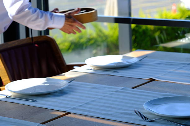 Close up view of table set checkered tablecloth with utensils and glasses in outdoor restaurant on Curacao.