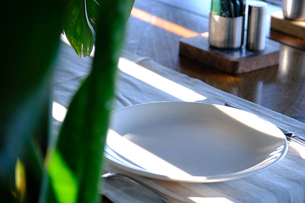 Table arrangement before dinner at a luxury restaurant. Waiters' service preparations. White tablecloths. Design of plates, forks and knives. Celebration dinner, lunch. Restaurant with Bosphorus view. Elegant dining table. Dinner chair.