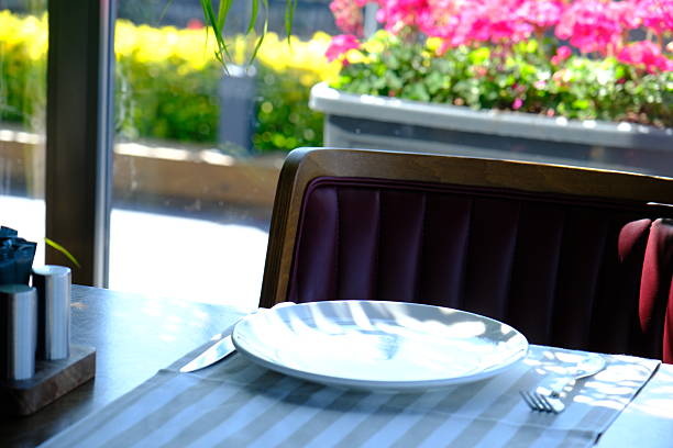 Setup of a table for dinner or lunch with modern and tasteful plates and decorative elements.