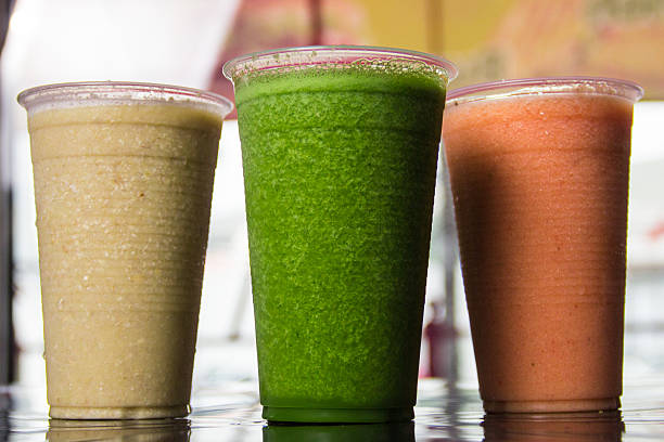 Three colorful smoothie drinks displayed in clear cups, showcasing vibrant colors and a refreshing appearance, ideal for a hot day or healthy snack.