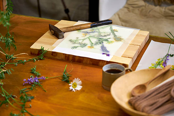 istock Wildflowers arranged under parchment paper, ready for botanical hammer art. Floral imprint preparation on wooden board, creative eco-friendly craft 2221189251