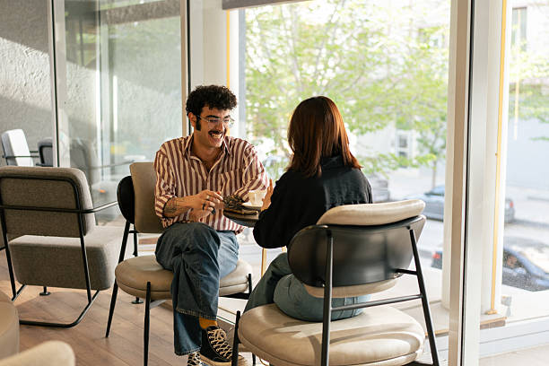 istock Young couple enjoying coffee and conversation in a modern cafe 2221195445