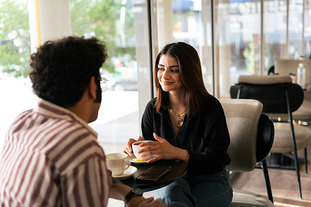 istock Young couple talking and drinking tea in a cafe 2221195551