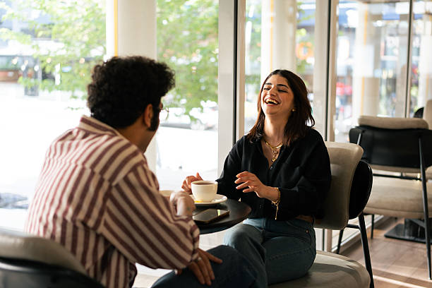 istock Young couple enjoying coffee and conversation in modern cafe 2221195652