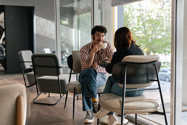 istock Young couple enjoying coffee and conversation in modern cafe 2221195793