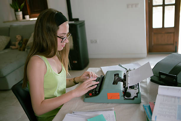 istock Young woman doing homework on a typewriter 2221205975