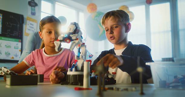 istock Primary School Children Sitting at Table, Studying Robotic Arm Model 2221209367