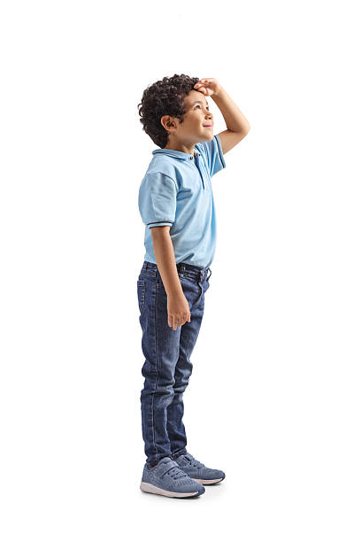 Full length profile shot of a boy looking up isolated on white background