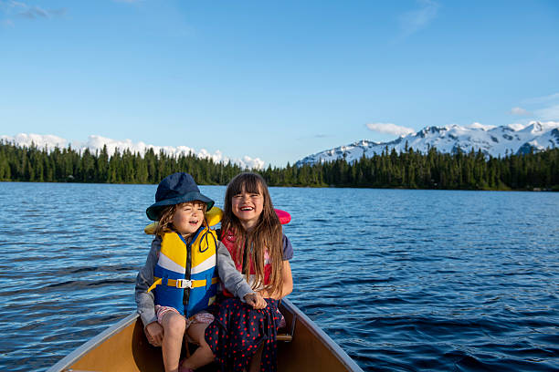 istock Young girls in canoe on tranquil lake 2221213028