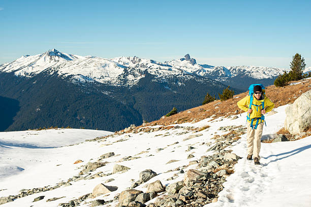istock Backpacker hikes through snow above lake 2221216279